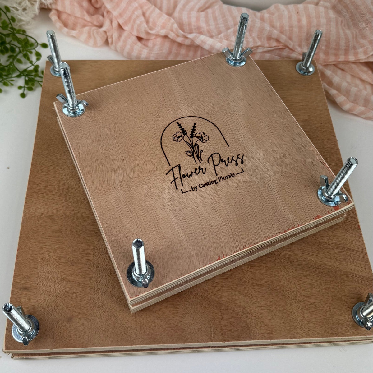 Wooden flower press with metal clips on a white background